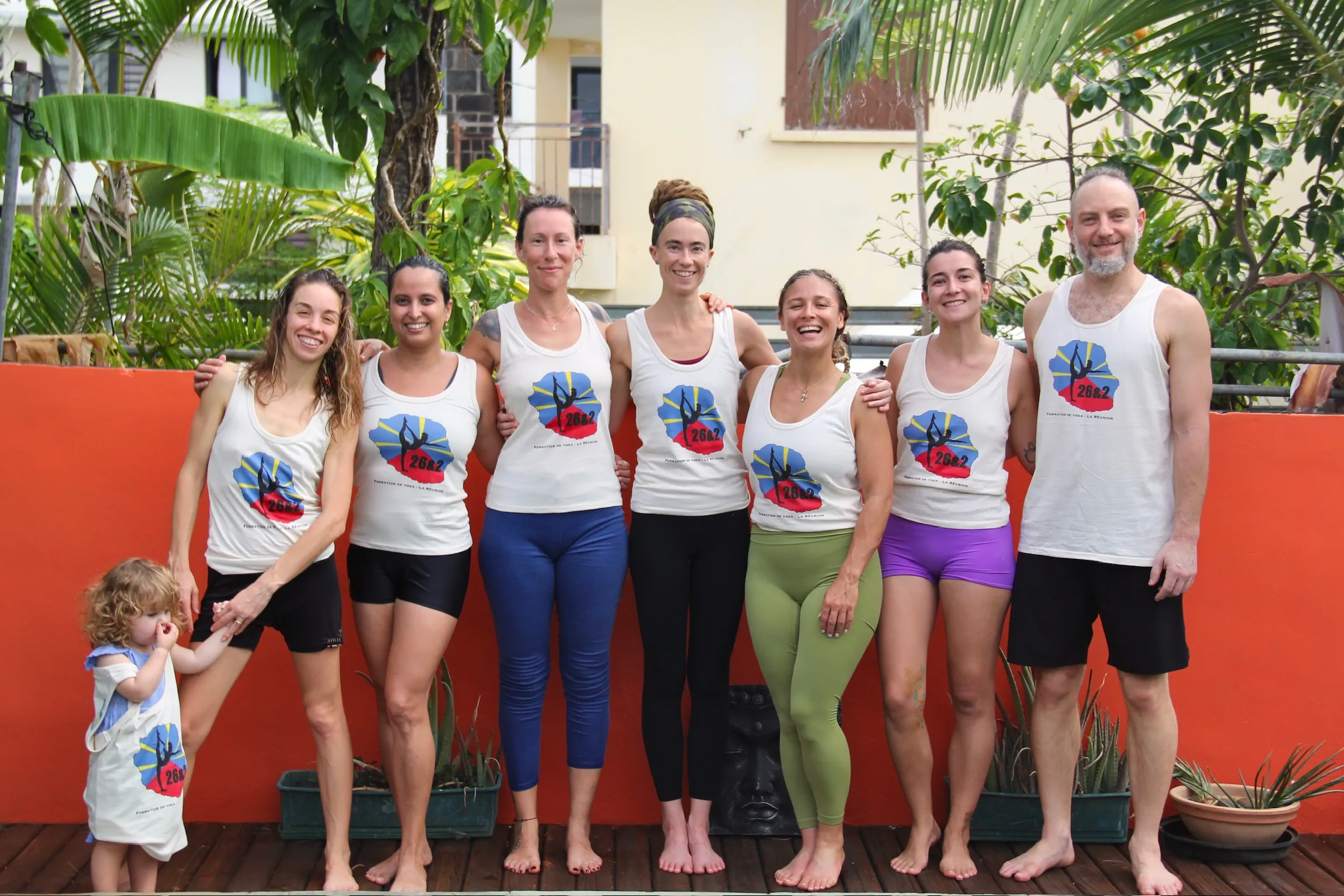 A line of graduates wearing their academy gear, ready to lead classes globally after completing one of the best yoga teacher training programs in the industry.