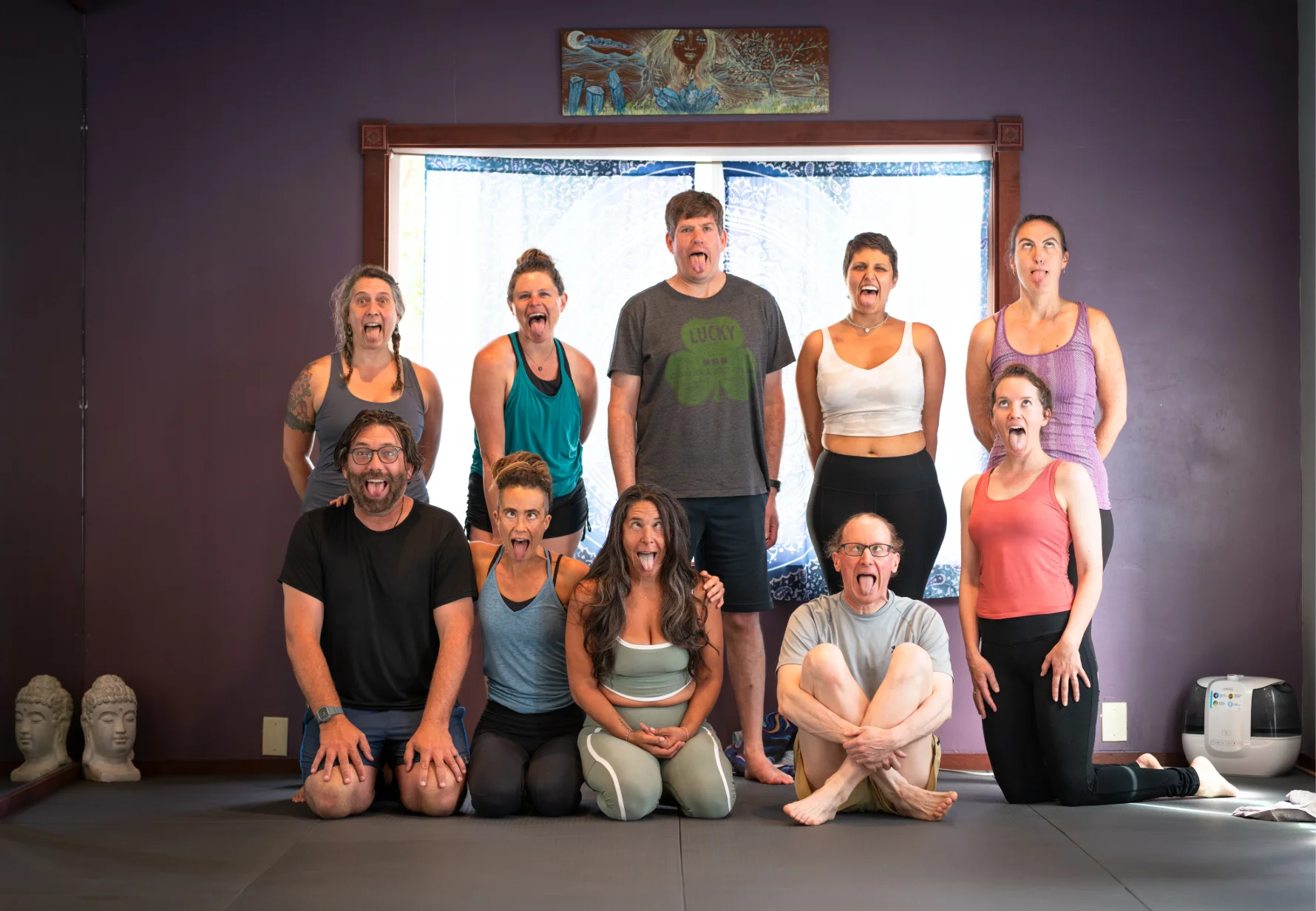 Yoga group making fun "Lion's Breath" faces for a community photo.