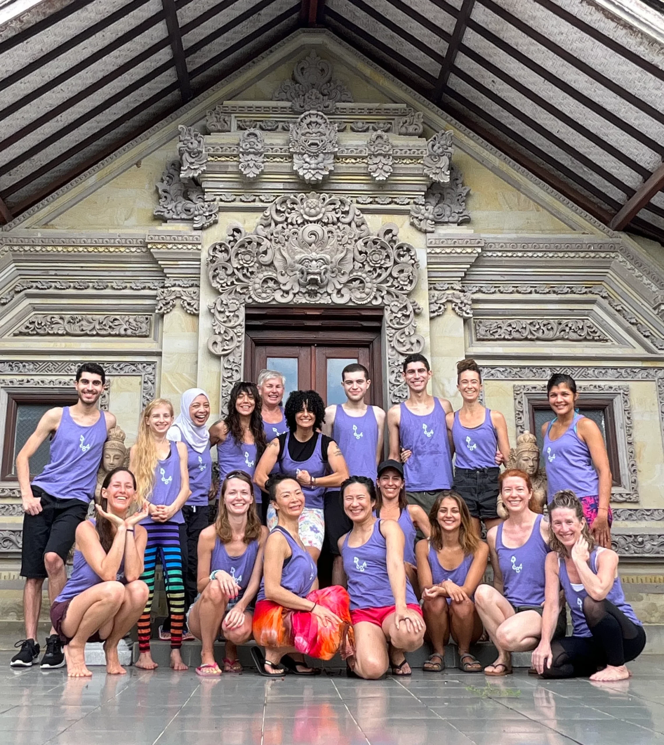 A diverse group of students smiling together at a temple during one of the best yoga teacher training in the world experiences.