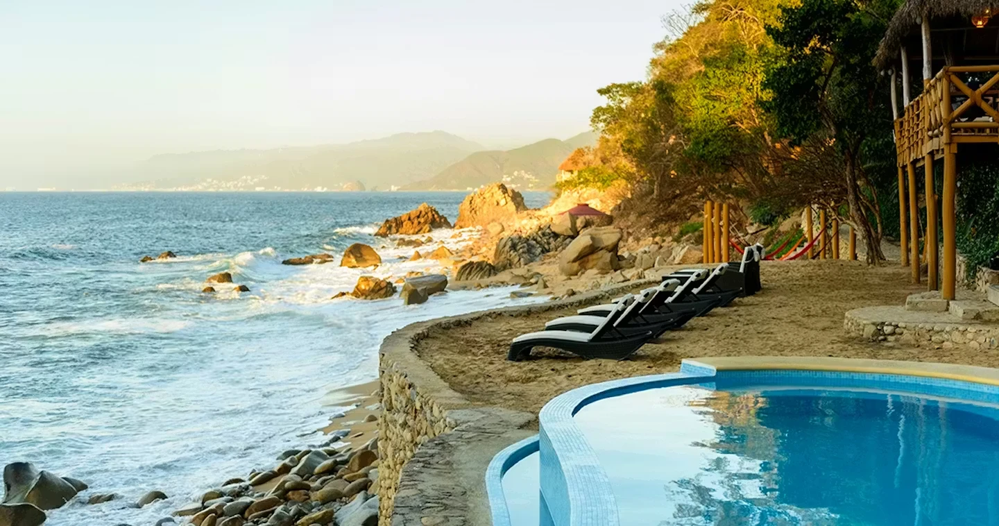 An infinity pool overlooking the coastline at a best yoga retreats in mexico.