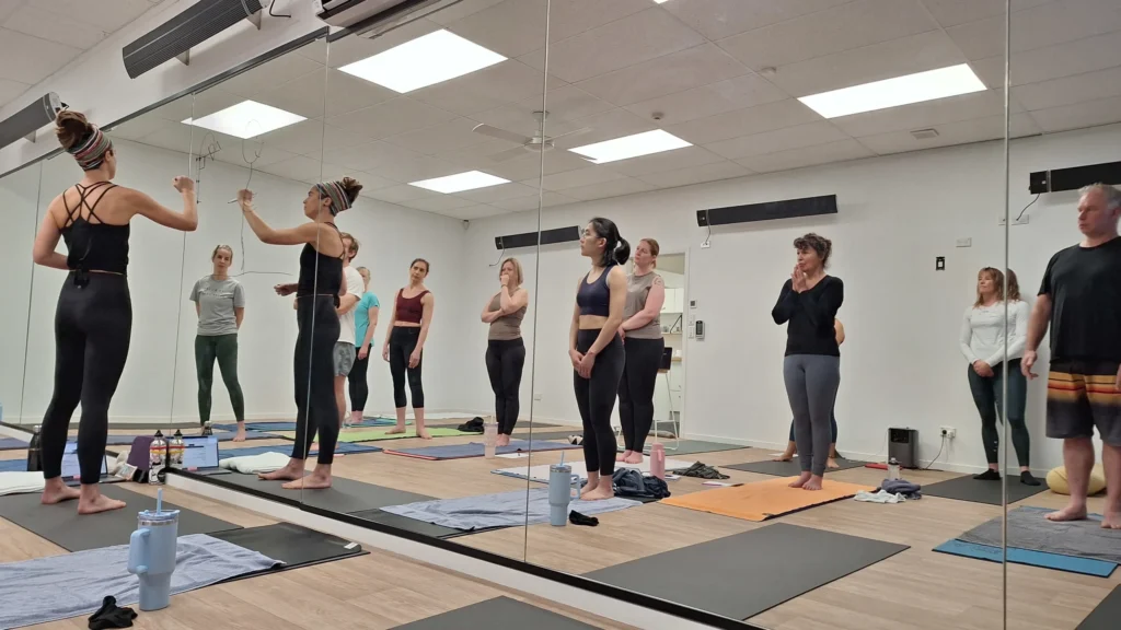 Yoga instructor drawing anatomical diagrams on a studio mirror for a workshop.